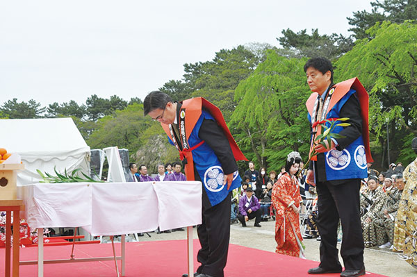 夢童先生に百合の花を献花する知事と市長。